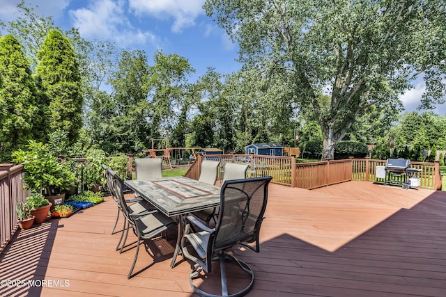 70 Desai Ct, Freehold, NJ 07728 - deck with outdoor dining space, a shed, view of wooded area, and a grill