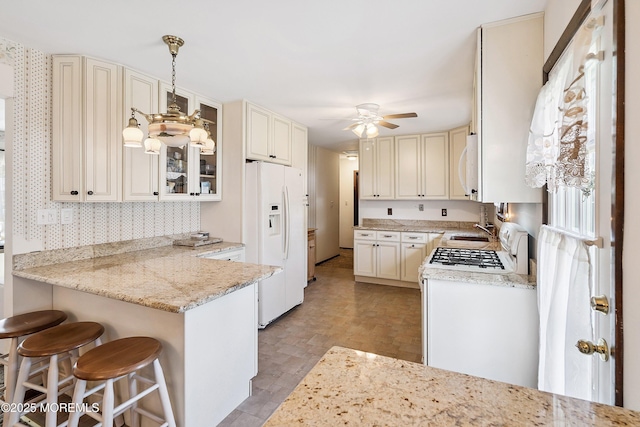 620 Pacific Ave, Beachwood, NJ 08722 - kitchen featuring white appliances, a ceiling fan, a peninsula, glass insert cabinets, and a kitchen bar