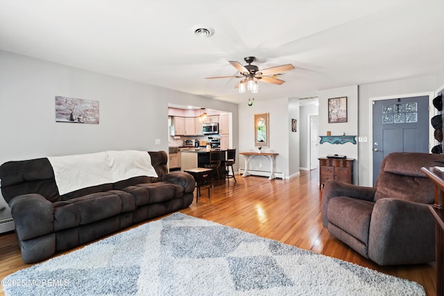 1086 Edgebrook Dr S, Toms River, NJ 08757 - living area featuring light wood-style floors, a ceiling fan, and a baseboard heating unit
