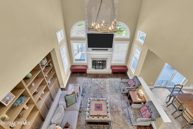 10 Biscayne Ct, Jackson, NJ 08527 - living room featuring a towering ceiling, a chandelier, a large fireplace, and wood finished floors