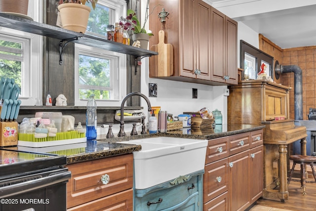 614 Bay Blvd, Bayville, NJ 08721 - kitchen with dark stone counters, brown cabinets, and light wood-style flooring