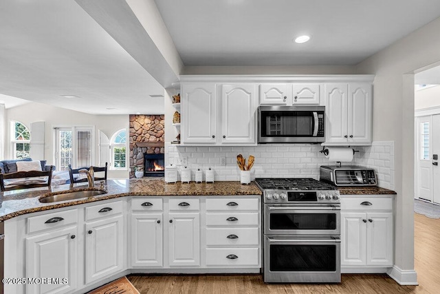 101 Taft Ct, Brick, NJ 08724 - kitchen featuring appliances with stainless steel finishes, dark stone countertops, light wood-style floors, white cabinetry, and healthy amount of natural light