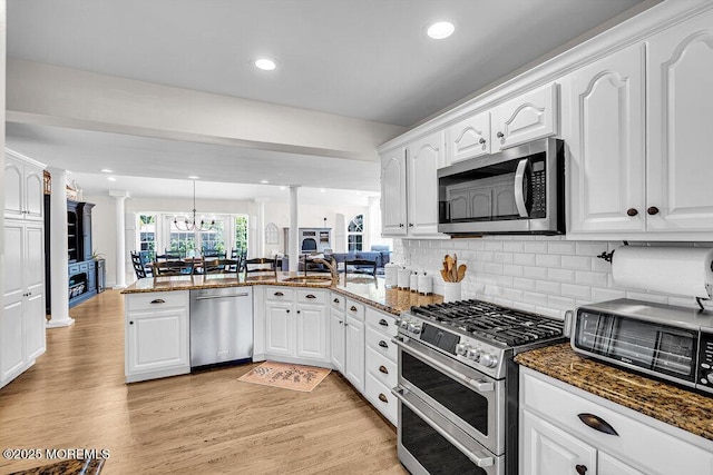 101 Taft Ct, Brick, NJ 08724 - kitchen with appliances with stainless steel finishes, decorative columns, a peninsula, white cabinets, and dark stone counters
