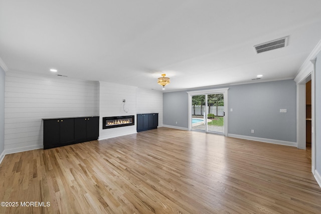 34 Traymore Rd, Freehold, NJ 07728 - unfurnished living room featuring ornamental molding, light wood-style floors, a glass covered fireplace, and recessed lighting