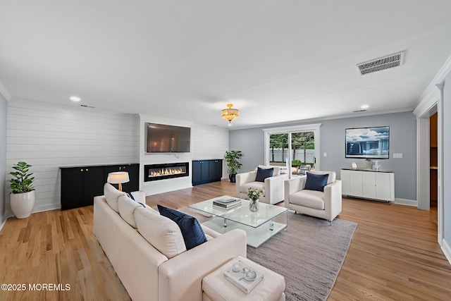 34 Traymore Rd, Freehold, NJ 07728 - living room featuring a glass covered fireplace, light wood finished floors, crown molding, and recessed lighting