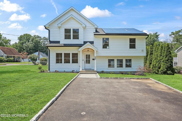 569 Ocean Blvd, Leonardo, NJ 07737 - view of front of property featuring roof mounted solar panels, a front yard, and board and batten siding