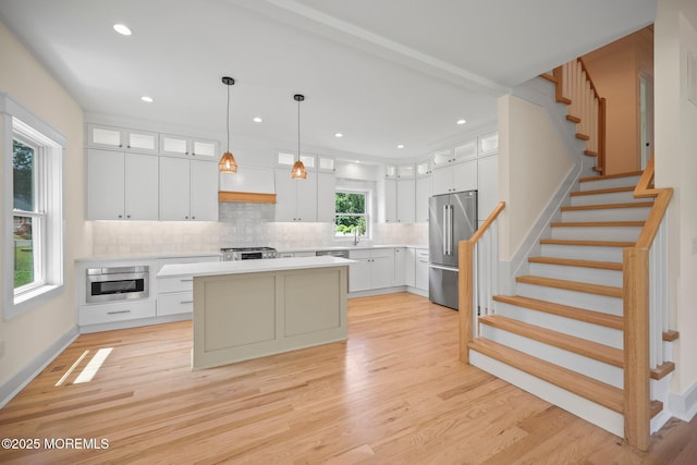 569 Ocean Blvd, Leonardo, NJ 07737 - kitchen with high quality fridge, decorative backsplash, light countertops, a kitchen island, and white cabinets