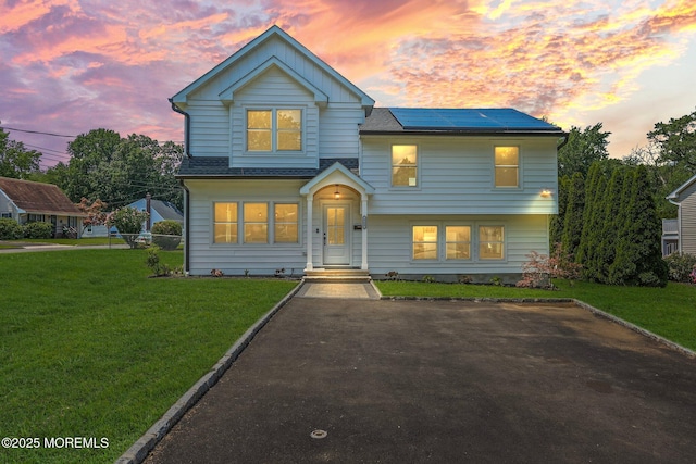 569 Ocean Blvd, Leonardo, NJ 07737 - view of front of house featuring solar panels, a front lawn, and board and batten siding