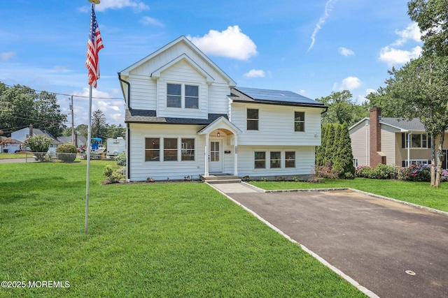 569 Ocean Blvd, Leonardo, NJ 07737 - view of front of house with solar panels, a front yard, and board and batten siding