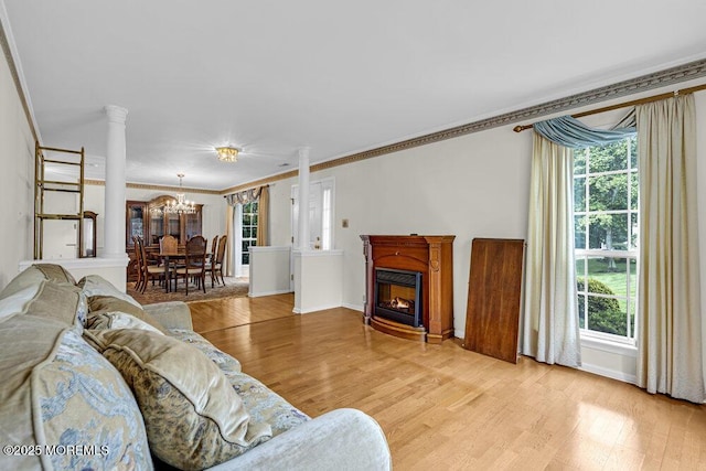 106 Tarpon Dr, Sea Girt, NJ 08750 - living area featuring a chandelier, light wood-type flooring, ornamental molding, ornate columns, and a glass covered fireplace