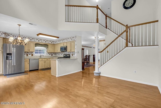 106 Tarpon Dr, Sea Girt, NJ 08750 - kitchen featuring appliances with stainless steel finishes, light countertops, light wood finished floors, a chandelier, and a high ceiling