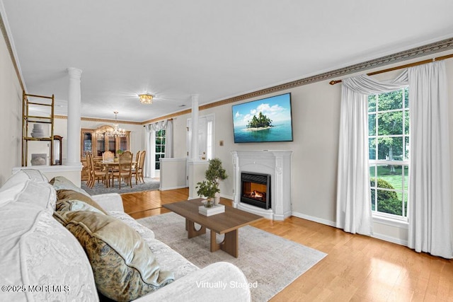 106 Tarpon Dr, Sea Girt, NJ 08750 - living area with healthy amount of natural light, light wood-style floors, a chandelier, crown molding, and a glass covered fireplace