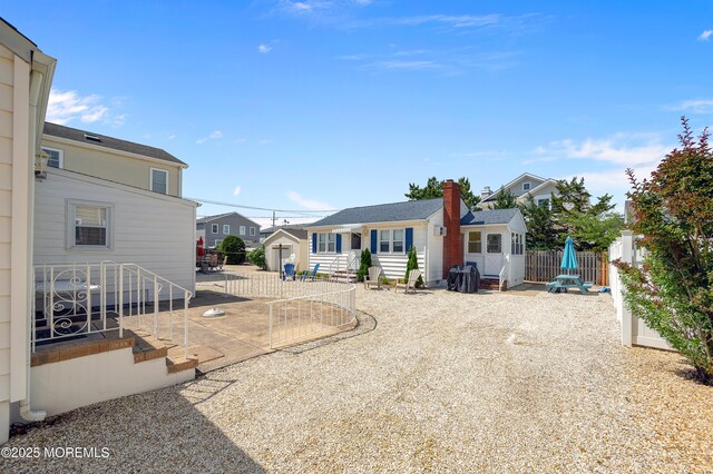 19 Elizabeth Ave, Lavallette, NJ 08735 - back of house with a residential view, a chimney, and an outdoor structure