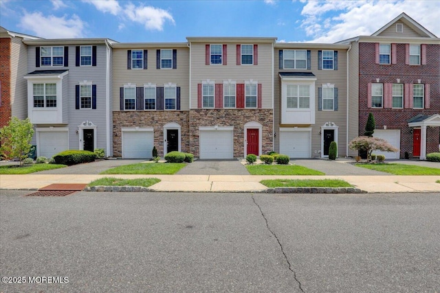108 Warbler Way, Freehold, NJ 07728 - townhome / multi-family property with stone siding, a garage, and driveway