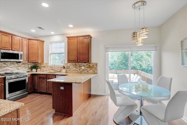 108 Warbler Way, Freehold, NJ 07728 - kitchen with stainless steel appliances, a peninsula, tasteful backsplash, light stone counters, and recessed lighting
