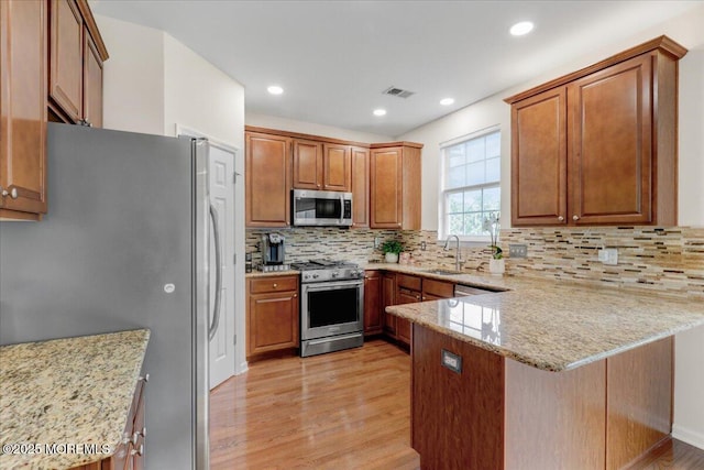 108 Warbler Way, Freehold, NJ 07728 - kitchen featuring stainless steel appliances, a peninsula, light wood finished floors, light stone counters, and recessed lighting