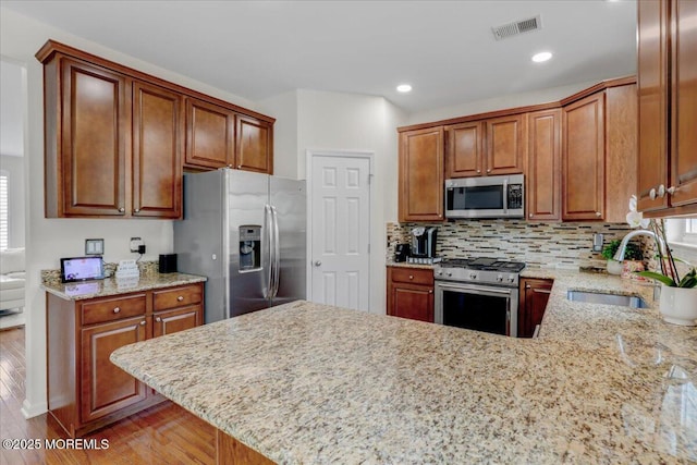 108 Warbler Way, Freehold, NJ 07728 - kitchen with stainless steel appliances, light wood finished floors, a peninsula, light stone countertops, and recessed lighting