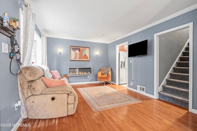 15 Park Blvd, Ocean Twp, NJ 07712 - living room with hardwood / wood-style flooring, stairway, ornamental molding, and a glass covered fireplace
