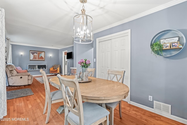 15 Park Blvd, Ocean Twp, NJ 07712 - dining area featuring light wood-type flooring, crown molding, and a chandelier