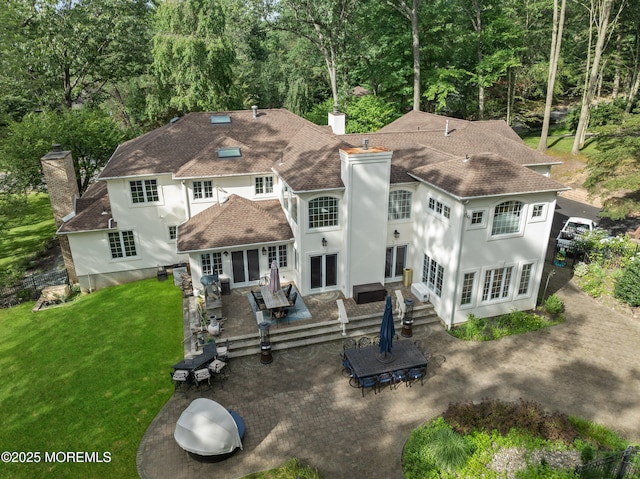 79 Cypress Neck Rd, Lincroft, NJ 07738 - back of house with a chimney, a yard, stucco siding, and a shingled roof