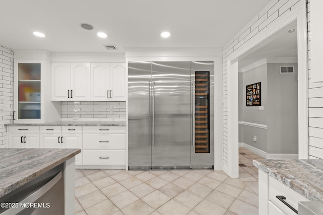 79 Cypress Neck Rd, Lincroft, NJ 07738 - kitchen featuring built in fridge, light stone countertops, backsplash, white cabinetry, and crown molding