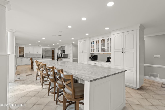 79 Cypress Neck Rd, Lincroft, NJ 07738 - kitchen featuring recessed lighting, light tile patterned floors, white cabinetry, glass insert cabinets, and decorative columns