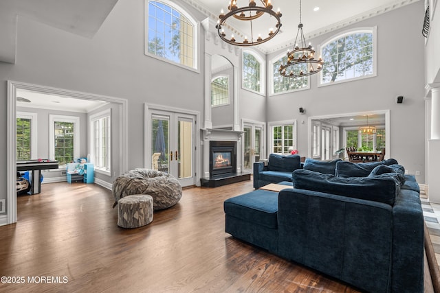 79 Cypress Neck Rd, Lincroft, NJ 07738 - living area with a chandelier, a glass covered fireplace, wood finished floors, a towering ceiling, and ornamental molding