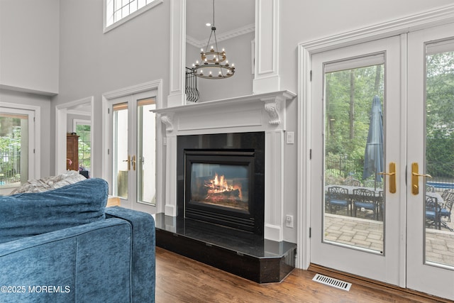 79 Cypress Neck Rd, Lincroft, NJ 07738 - living area with french doors, plenty of natural light, wood finished floors, a glass covered fireplace, and crown molding