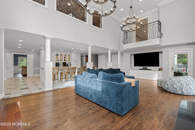 79 Cypress Neck Rd, Lincroft, NJ 07738 - living area featuring decorative columns, ornamental molding, wood finished floors, a towering ceiling, and healthy amount of natural light