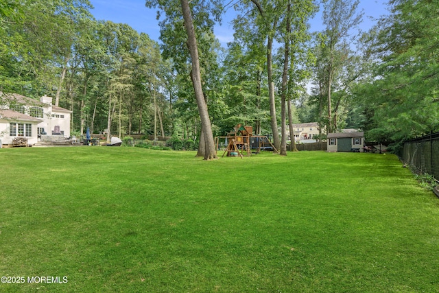 79 Cypress Neck Rd, Lincroft, NJ 07738 - fenced backyard featuring a storage unit, a playground, and view of wooded area