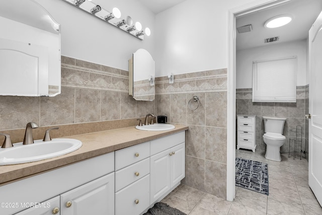 100 Case Rd, Lakewood, NJ 08701 - full bath with tile walls, double vanity, tile patterned floors, and a wainscoted wall