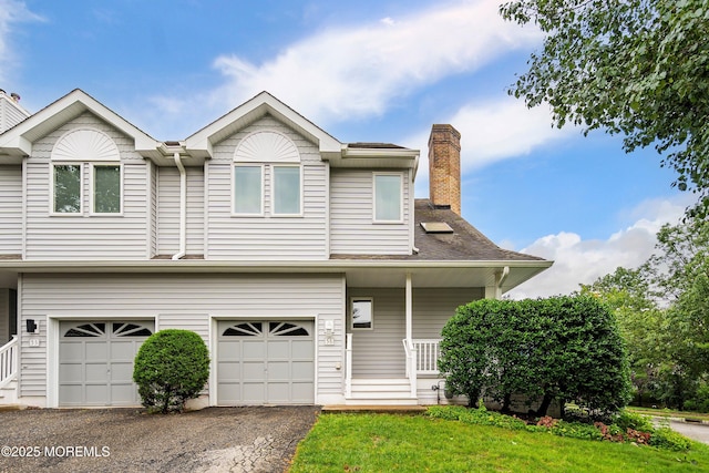56 Violet Ct, Toms River, NJ 08753 - view of front of house with an attached garage, a chimney, covered porch, and asphalt driveway