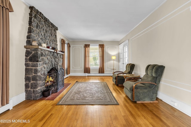 28 Broadway Rd, Freehold, NJ 07728 - sitting room with baseboard heating, hardwood / wood-style floors, a stone fireplace, and crown molding