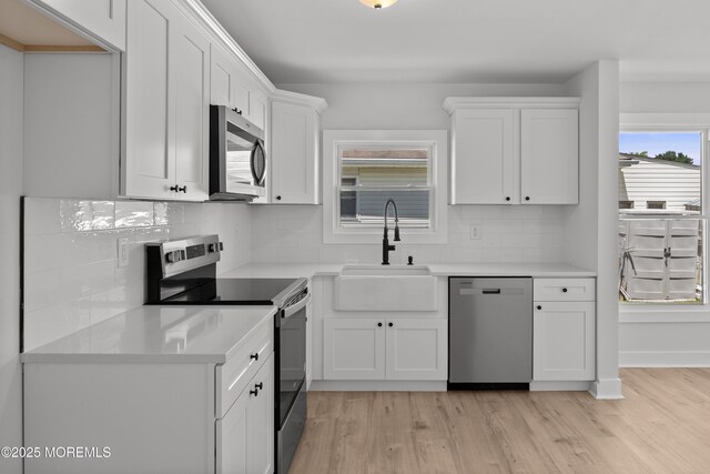 503 Jamaica Blvd, Toms River, NJ 08757 - kitchen featuring appliances with stainless steel finishes, white cabinets, light wood-type flooring, and tasteful backsplash