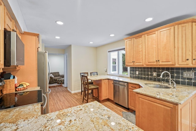 11 Hazelwood Ct, Howell, NJ 07731 - kitchen with appliances with stainless steel finishes, light wood finished floors, light stone countertops, a peninsula, and backsplash