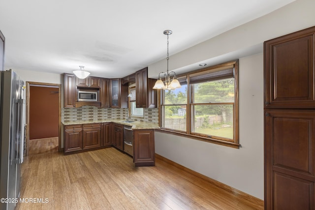 444 Pfister Rd, Jackson, NJ 08527 - kitchen featuring stainless steel appliances, light wood-type flooring, tasteful backsplash, a chandelier, and light stone counters