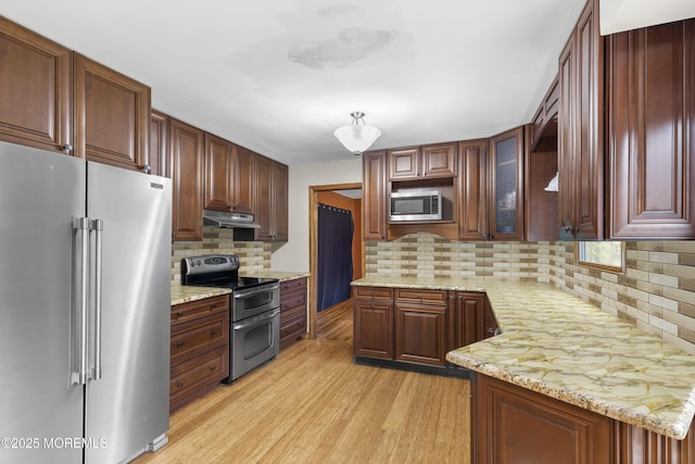 444 Pfister Rd, Jackson, NJ 08527 - kitchen with appliances with stainless steel finishes, under cabinet range hood, light wood finished floors, decorative backsplash, and glass insert cabinets