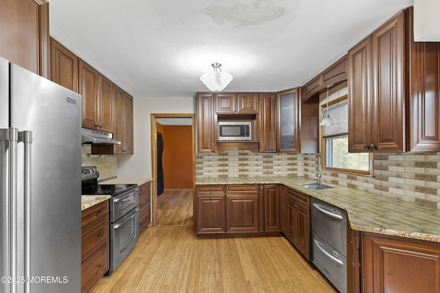 444 Pfister Rd, Jackson, NJ 08527 - kitchen with stainless steel appliances, under cabinet range hood, light wood-style flooring, backsplash, and light stone counters