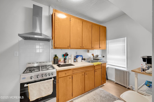 402 2nd Ave, Long Branch, NJ 07740 - kitchen with wall chimney exhaust hood, radiator, range with gas cooktop, vaulted ceiling, and light wood finished floors