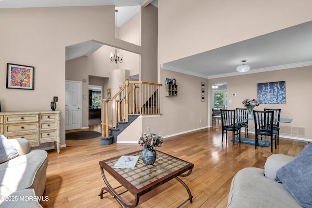 16 Arrowhead Way, Millstone, NJ 08535 - living room with stairway, light wood-style floors, a chandelier, high vaulted ceiling, and crown molding