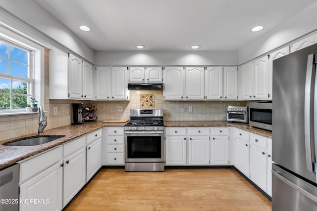 16 Arrowhead Way, Millstone, NJ 08535 - kitchen featuring appliances with stainless steel finishes, under cabinet range hood, dark stone countertops, tasteful backsplash, and white cabinets