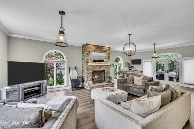 2 Shady Oak Ct, Millstone, NJ 08535 - living room featuring a stone fireplace, wood finished floors, crown molding, a chandelier, and french doors