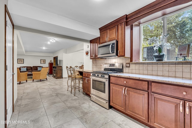 2 Shady Oak Ct, Millstone, NJ 08535 - kitchen with appliances with stainless steel finishes, decorative backsplash, light stone counters, and brown cabinetry