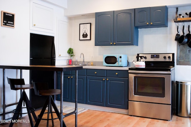 1730 Newman St, Belmar, NJ 07719 - kitchen featuring stainless steel electric stove, blue cabinets, and decorative backsplash