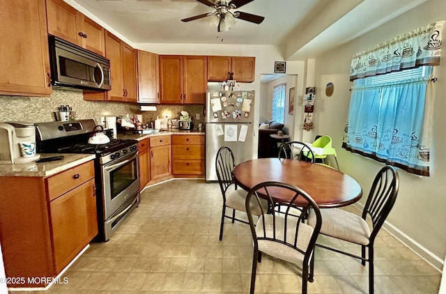 38 Crescent St, Keansburg, NJ 07734 - kitchen with stainless steel appliances, backsplash, ceiling fan, and brown cabinetry