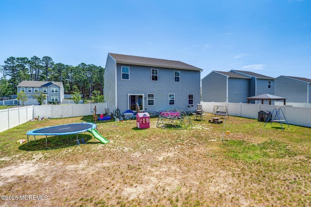 107 Sandpiper Ln, Little Egg Harbor, NJ 08087 - rear view of property with a trampoline, a fenced backyard, and an outdoor fire pit