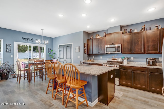 107 Sandpiper Ln, Little Egg Harbor, NJ 08087 - kitchen featuring stainless steel appliances, light wood finished floors, a chandelier, a kitchen island with sink, and a breakfast bar