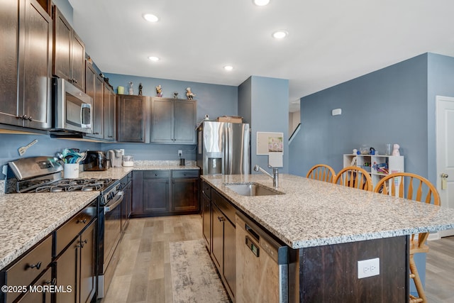 107 Sandpiper Ln, Little Egg Harbor, NJ 08087 - kitchen with stainless steel appliances, a breakfast bar, light wood-type flooring, a kitchen island with sink, and dark brown cabinets