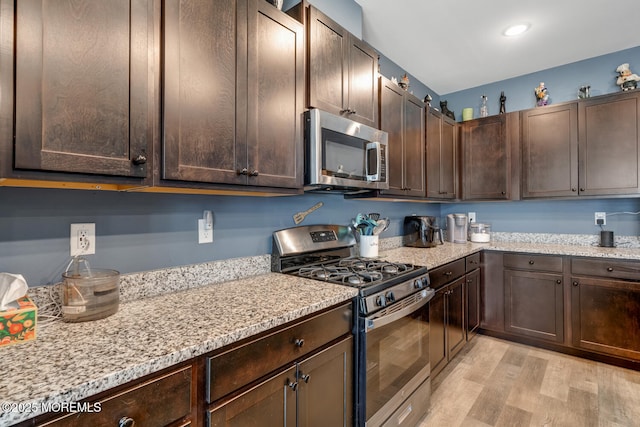 107 Sandpiper Ln, Little Egg Harbor, NJ 08087 - kitchen with stainless steel appliances, dark brown cabinets, light wood-type flooring, and light stone counters