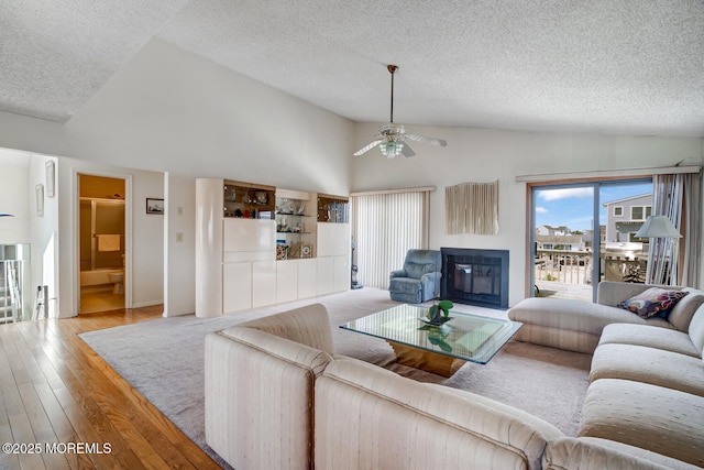 1856 Mill Creek Rd, Beach Haven West, NJ 08050 - living area with a textured ceiling, a ceiling fan, wood finished floors, high vaulted ceiling, and a glass covered fireplace